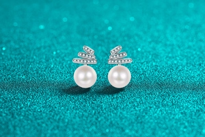 Macro shot of S925 silver earrings with sparkling moissanite and round white pearls