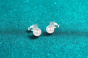 Macro shot of 925 silver pearl stud earrings with sparkling cubic zirconia crown detail