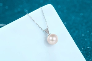 Detail of 10mm freshwater pearl necklace with V-shaped silver moissanite pendant