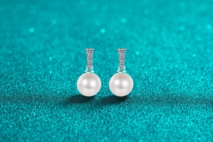 Detail of S925 silver pearl earrings with three vertically aligned brilliant diamonds