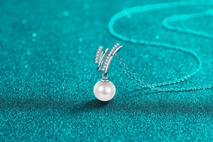 Close-up of S925 silver pendant with micro-pave diamonds and a round white pearl