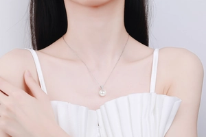 Close-up of 10mm freshwater pearl and moissanite necklace on a model clavicle