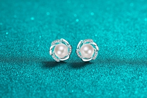 Macro shot of S925 silver pearl stud earring with pavé-set crystals in a flower design