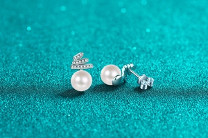 Macro shot of S925 silver stud earrings with round pearls and sparkling Moissanite accents
