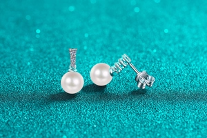 Macro view of S925 silver pearl earrings with three brilliant cubic zirconia stones