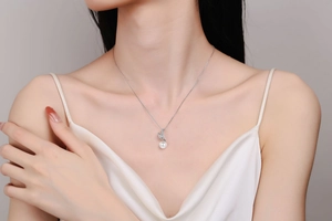 Close-up of S925 silver necklace with a round white pearl and sparkling pavé diamond pendant