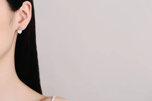 Detailed view of S925 silver pearl earring with sparkling moissanite on a model