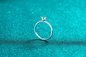 Detailed side view of silver ring showing heart-shaped cutout and round cut gemstone
