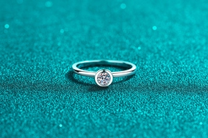 Macro shot of S925 sterling silver ring with a bezel-set moissanite on starry background