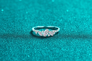 Detaillierte Makroansicht des S925 Silberrings mit Marquise-Schliff auf blauem Glitzer