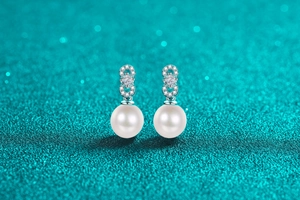 Macro detail of S925 silver pearl earrings with sparkling moissanite accents
