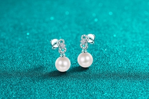 Macro shot of S925 sterling silver pearl earrings with sparkling infinity zircon design