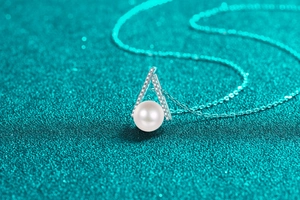 Makro-Detail von S925 Silber V-Anhänger mit weißer Perle und funkelnden Pavé-Diamanten