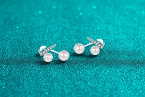 Macro shot of S925 silver cherry earrings with white pearls and micro-pave crystals