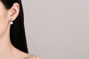 Detailed close-up of a S925 silver pearl earring featuring a Moissanite infinity stud