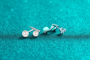 Close-up of S925 silver T-shape cherry earrings with moissanite and round white pearls