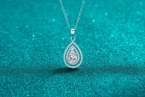 Macro shot of S925 silver pear-shaped pendant featuring double halo moissanite setting