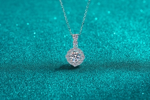 Détail d'un pendentif en moissanite en argent S925 avec serti halo sur fond pailleté