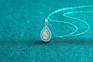 Macro shot of S925 silver pear-shaped double halo moissanite pendant with pavé diamonds