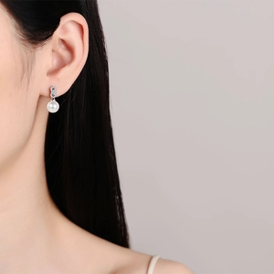 S925 sterling silver pearl earrings featuring infinity zircon design on female model