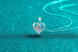 Macro detail of sterling silver heart pendant featuring a sparkling moissanite main stone