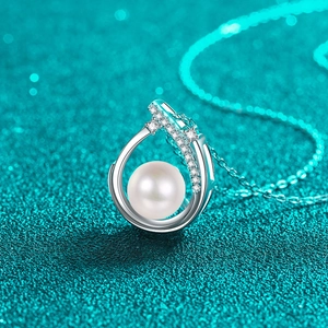 Collier en argent S925 avec perle et accents de moissanite sur fond bleu scintillant