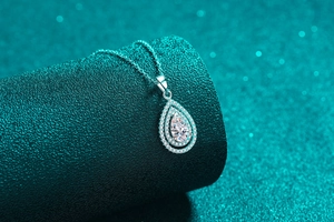 Macro shot of S925 silver pear shaped moissanite necklace with shimmering halo detail