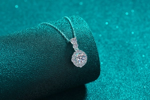 Détail macro du pendentif en moissanite argent S925 avec sertissage sur fond bleu sarcelle