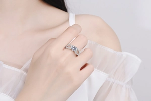 Close-up of S925 silver moissanite ring with infinity twist design on model's finger