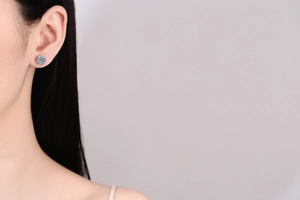 Close-up of S925 sterling silver moissanite halo stud earrings worn by a model