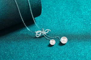 Detailed macro view of 925 silver bow pendant with moissanite accents and white pearls