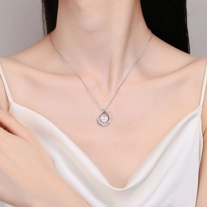 Collier élégant en argent S925 avec perle blanche ronde sur une robe en soie
