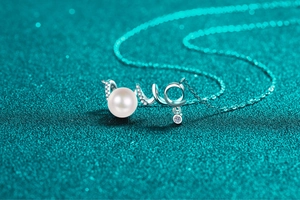 Close-up of S925 silver pearl necklace with a moissanite-encrusted fluid pendant detail