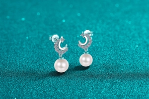 Close-up of S925 silver star and moon earrings with glossy white round pearls