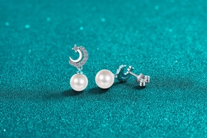 Detailed close-up of S925 silver crescent moon earrings with diamonds and white pearls