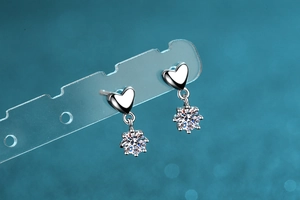 Détail de boucles d'oreilles cœur en argent 925 avec pierres de moissanite brillantes