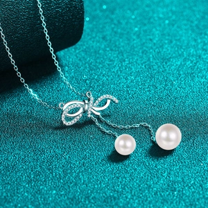 925 silver necklace featuring a sparkling bow pendant and elegant twin pearl tassels