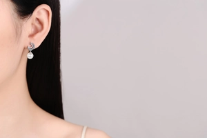 Detail of S925 silver star and moon earrings with white pearls on a female model