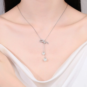 925 silver necklace with moissanite bow pendant and elegant pearl tassels worn by a model
