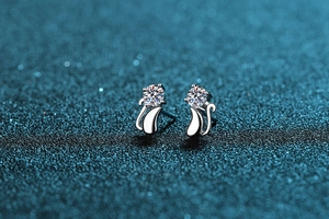 Macro shot of S925 sterling silver cat-shaped stud earrings with sparkling moissanite stone