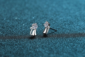Macro detail of S925 sterling silver cat stud earrings with sparkling moissanite stones