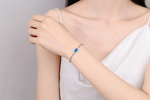 Detail of adjustable S925 silver bracelet with marquise blue stone on model wrist