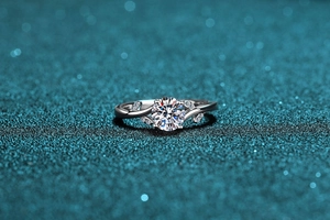 Vue macro d'une bague moissanite 1ct avec design feuille sur fond scintillant de bokeh