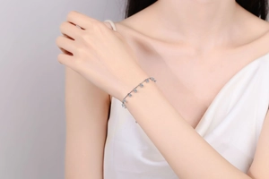 Détail du bracelet en argent S925 avec moissanite et pendentifs bleu clair sur le poignet