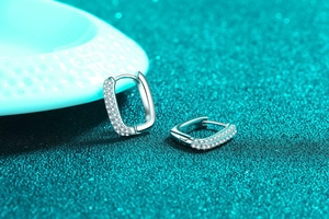 Macro shot of silver rectangular huggie earrings with double-row micro-pave crystals