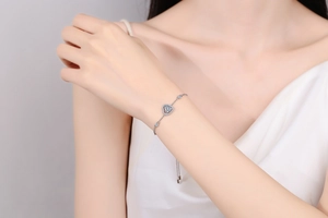 Nahaufnahme des S925 Sterlingsilber-Armbands mit blauem Herz-Edelstein am Handgelenk