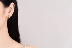 Close-up of S925 sterling silver hoop earrings with pave moissanite on a model ear