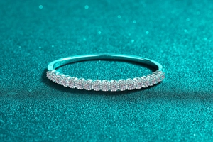 Gros plan d'un bracelet en argent S925 avec moissanite pavée sur fond bleu scintillant