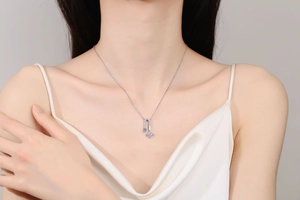 Detail of square moissanite S925 silver pendant necklace worn on a female model