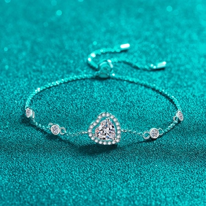 Eleganter S925 Sterlingsilber Herzarmreif mit blauem Moissanit auf blauem Glitzerhintergrund